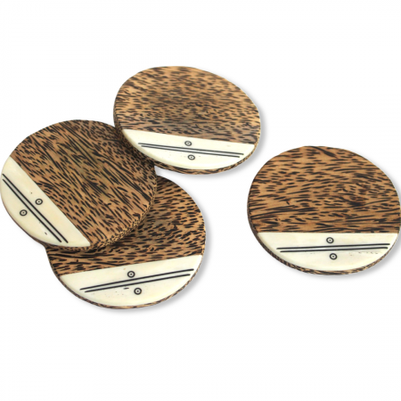 4 round palm wood coasters that are dark brown in color, with a cheetah print, have a smooth surface, and that have a white smooth marble looking inlay along the bottom edge of each coaster. The white inlay is made from upcycled cow bone. The white inlay also has two hand drawn black horizontal lines, with a tiny black circle above and below the lines.